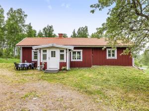 a red house with a table in front of it at Chalet Motorp by Interhome in Arboga