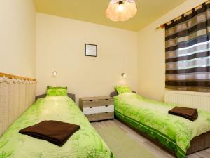 two beds in a bedroom with green sheets at Holiday Home Toth by Interhome in Badacsony
