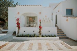 Una casa blanca con escalera y flores. en Can Blau - Mediterranean Living, en Jávea