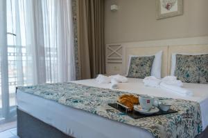索佐波爾的住宿－Cristiani Hotel Sozopol，一间酒店客房,配有一张床铺,上面放着一个食物托盘