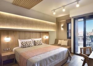 um quarto com uma cama grande e uma varanda em CORYLUS Luxury Rooms & Suites em Leptokarya