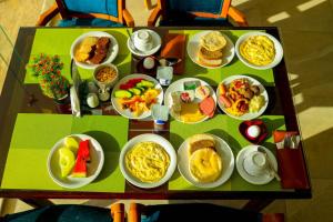 a table with plates of breakfast food on it at Shellghada Blue Beach in Hurghada