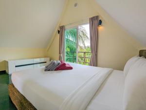 a bedroom with a large white bed with a window at Villa with Private Pool - by KohChangVillas in Ko Chang