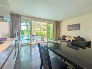 a kitchen and living room with a couch and a table at Villa with Private Pool - by KohChangVillas in Ko Chang