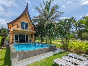 a villa with a swimming pool in front of a house at Villa with Private Pool - by KohChangVillas in Ko Chang
