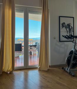 un soggiorno con una porta che si apre su un balcone di Apartments Villa Klaudia - Adults Only a Crikvenica