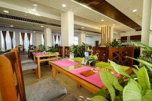 a restaurant with tables and chairs and plants at Shellghada Blue Beach in Hurghada