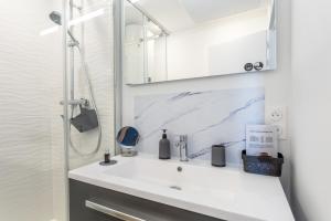 a white bathroom with a sink and a shower at Appartement - 50m de la mer in Fouesnant +17 photos