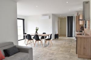 a living room with a couch and a table and chairs at Maisons Phoenix in Saint-Jean-de-Monts