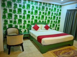 a bedroom with a bed and a chair in a room at Royal shades kodihali in Bangalore