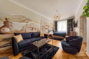 a living room with a blue couch and a painting at Mikołajska 5 Apartments in Kraków