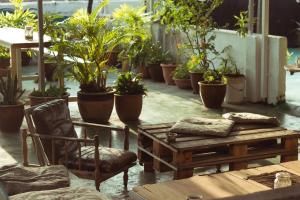 a patio with tables and chairs and potted plants at Ringo's Foyer in Melaka