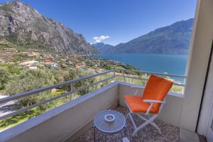 - un balcon avec une chaise, une table et de l'eau dans l'établissement Hotel Villa Margherita, à Limone sul Garda