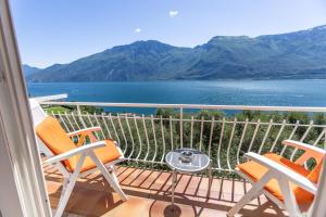 a balcony with chairs and a view of the water at Hotel Villa Margherita in Limone sul Garda