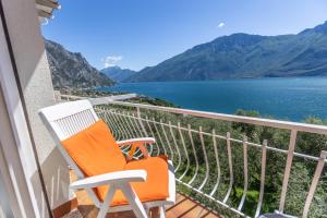 a chair on a balcony with a view of the water at Hotel Villa Margherita in Limone sul Garda