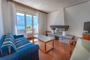 - un salon avec un canapé bleu et une cheminée dans l'établissement Hotel Villa Margherita, à Limone sul Garda