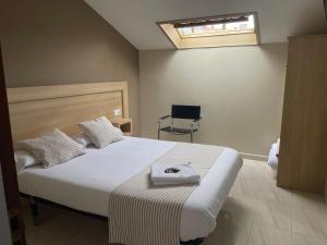 1 dormitorio con 1 cama y 1 silla en CASA MARUXA pensión, en Pontevedra