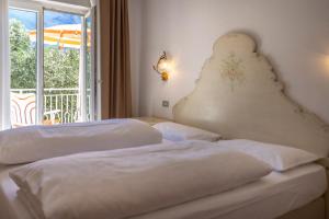 a hotel room with two beds and a balcony at Hotel Villa Margherita in Limone sul Garda