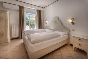 a bedroom with a white bed and a window at Hotel Villa Margherita in Limone sul Garda