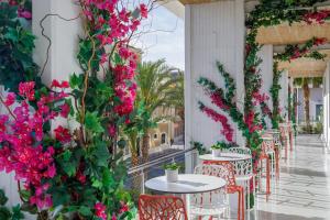 a row of tables and chairs with pink flowers at Melia Alicante in Alicante