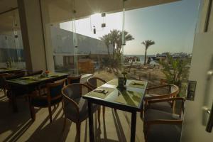 a restaurant with tables and chairs and a view of the beach at Shellghada Blue Beach in Hurghada