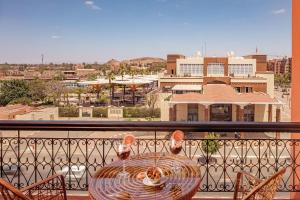 - une table sur un balcon avec vue sur la ville dans l'établissement Red Hotel Marrakech, à Marrakech