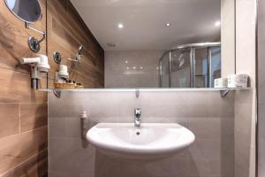 a bathroom with a white sink and a mirror at Hotel Villa Margherita in Limone sul Garda