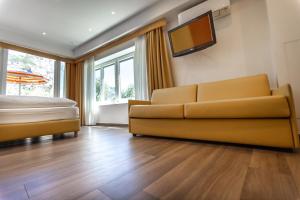 a living room with a couch and a bed at Hotel Villa Margherita in Limone sul Garda