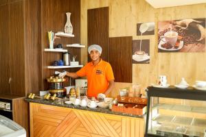 a man standing behind a counter in a kitchen at Shellghada Blue Beach in Hurghada
