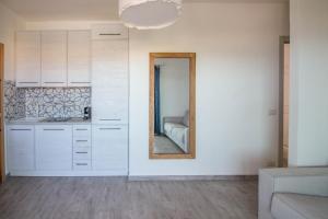 a kitchen with white cabinets and a mirror at Palau Lovely Sea View Apartment with Balcony in Palau +22 photos