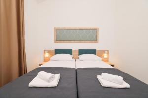 a bedroom with two beds with white towels on them at Apartments Medena in Trogir