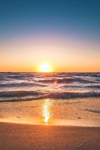 阿喬普羅柯皮歐斯的住宿－Virtu Suites，日落在海滩上与大海
