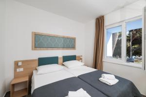 a bedroom with a large bed and a window at Apartments Medena in Trogir +62 photos
