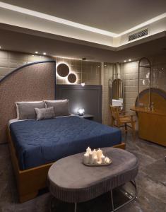 - une chambre avec un lit bleu et une table avec des bougies dans l'établissement CORYLUS Luxury Rooms & Suites, à Leptokaryá