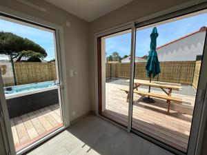a room with a sliding glass door with a picnic table at Maisons Phoenix in Saint-Jean-de-Monts