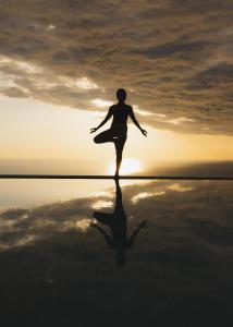 a woman doing yoga on the beach at sunset at SECRET HILL in Athani