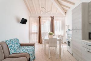 a living room with a couch and a table at Bagno Conte Rosso - Beachfront Suites & Apartments in Lido di Camaiore