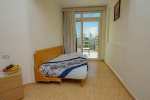 een slaapkamer met een bed en een glazen schuifdeur bij Andalusia Blue Beach Hurghada in Hurghada