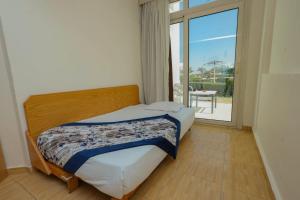 een slaapkamer met een bed en een groot raam bij Andalusia Blue Beach Hurghada in Hurghada