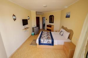 een slaapkamer met een bed en een televisie. bij Andalusia Blue Beach Hurghada in Hurghada