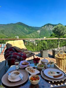 Hotel Borjomi Verde في بورجومي: طاولة مع أطباق من الطعام على سطح السفينة