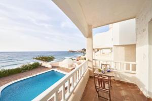 a balcony with a swimming pool and the ocean at Arriate in San José