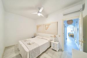 a white bedroom with a bed and a ceiling fan at Arriate in San José +35 photos