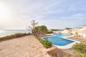 a swimming pool sitting next to the ocean at Arriate in San José