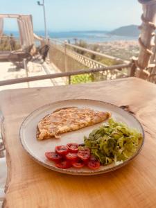 um prato de pizza e uma salada numa mesa em Semiramis em Lefkada