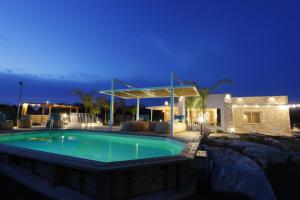 a swimming pool in front of a house at night at Villa Santo Spirito a 5 minuti da Otranto in Otranto