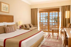een hotelkamer met een bed en een woonkamer bij Steigenberger Hotel & Nelson Village, Taba in Taba