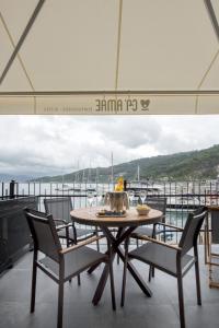 Ca' Amae Portovener e في بورتوفينيري: طاولة وكراسي على شرفة مع قارب