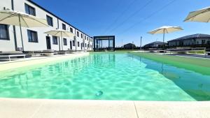 a swimming pool with umbrellas next to a building at X rent apartment in Prim Decembrie +52 photos