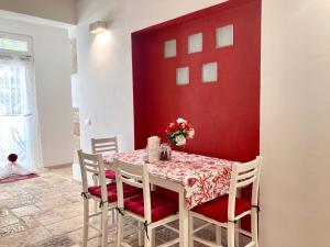 ポリニャーノ・ア・マーレにあるAntica Pietraの赤い壁のテーブル付きのダイニングルーム